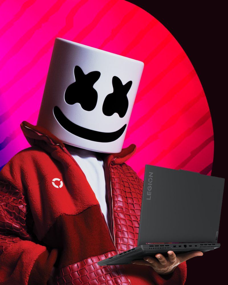 Marshmello in a Lenovo Legion-branded red leather jacket, holding a Legion laptop against a pink-and-blue gradient.